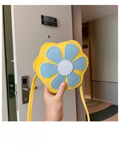 Close-up of yellow flower-shaped PU leather crossbody bag with blue petals and strap