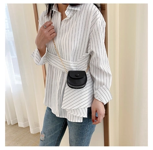 Detailed view of kids mini black saddle crossbody bag with gold chain strap on model