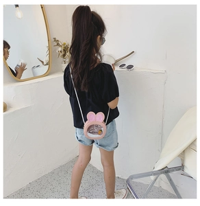 Pink kids bunny crossbody bag with sequin ears and carrot glitter on a young girl