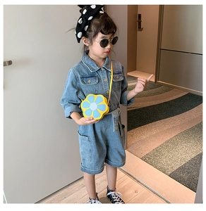 Detail of yellow flower crossbody bag paired with kids denim romper for summer styling