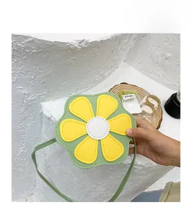 Close-up of a green flower-shaped kids crossbody bag with yellow leather petals