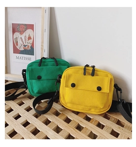 Detailed view of green and yellow canvas crossbody bags for kids with adjustable straps