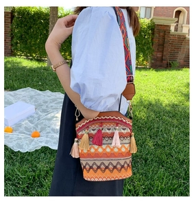 Dettaglio della borsa a secchiello tessuta boho con nappe vivaci e tracolla etnica