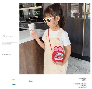 Close-up of kids red bunny shoulder bag with sequin carrot detail on a young model
