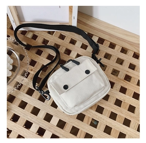 Detailed view of kids minimalist canvas crossbody bag with black straps and double zippers