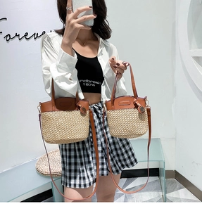 Detail view of woven straw tote bags with brown leather handles in two sizes