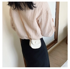 Detailed back view of a white mini PU leather saddle bag with a fine gold chain strap