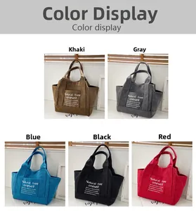 Detail view of multi-color canvas tote bags in khaki, gray, blue, black, and red colors