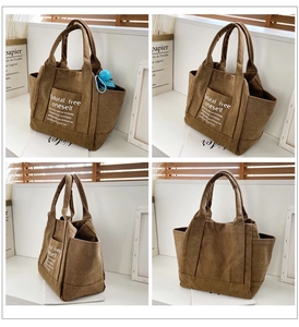Brown canvas tote bag detail view showing front text print and side storage pockets