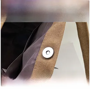 Detail of high-quality electroplated metal magnetic clasp on brown canvas mommy bag
