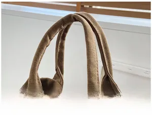 Close-up of thick brown canvas handles with reinforced stitching for comfortable grip