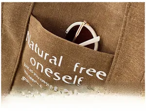 Close-up of brown canvas tote with external pocket and sunglasses detail
