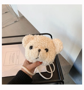 Close-up of cute cream sherpa bear crossbody bag showing soft plush texture and hand size