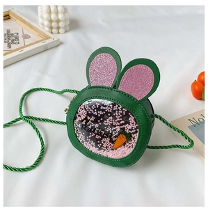 Close-up of green bunny ear bag featuring pink sequins and carrot patterns on white fabric
