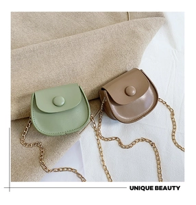 Close-up of mini semi-circle chain bags in mint green and brown faux leather