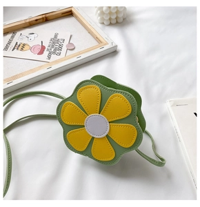 Detail of flower shaped kids crossbody bag with green yellow leather and slim strap