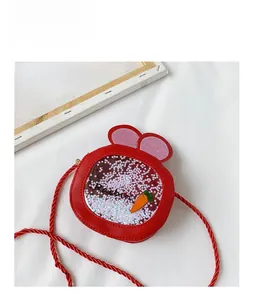 Detail of red rabbit ear crossbody bag featuring sequined carrot and star decorations