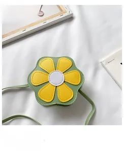 Detail of green and yellow flower-shaped mini crossbody bag for girls on white fabric