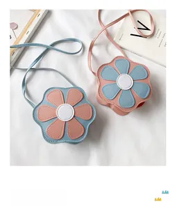 Detail of colorful flower-shaped PU leather crossbody bags for girls on soft white fabric