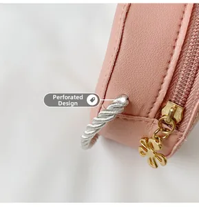 Detail of pink textured leather with floral gold zipper and perforated rope design