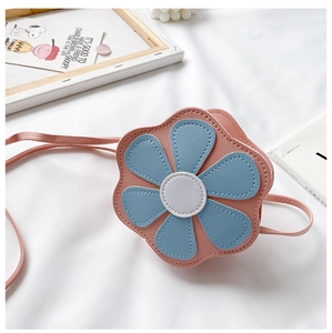 Detailed view of pink flower-shaped kid's crossbody bag with blue petals on white fabric