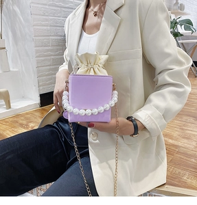 Detail of lavender square bag with large pearl handle and inner drawstring pouch