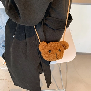 Cute brown plush teddy bear cross-body bag with a cord strap on a stylish model
