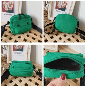 Detail view of a green canvas kids crossbody bag showing pockets and strap features