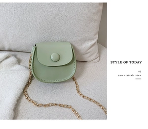 Detail of light green PU leather mini round bag with gold chain strap and snap closure