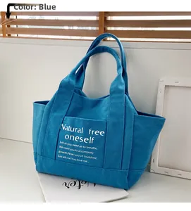 Blue canvas tote bag with poetic text print shown in a bright indoor window setting