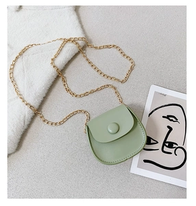 Detail of light green PU leather mini crossbody bag with gold chain and saddle design