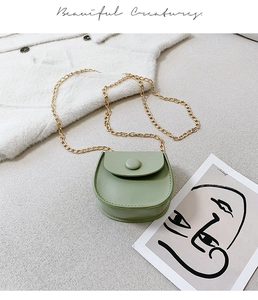 Detail of light green faux leather saddle bag with gold chain and matching button