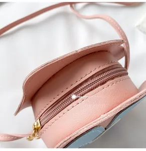 Detail of a smooth golden zipper on a pink and blue floral mini crossbody bag for girls