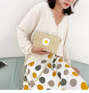 Détail du sac bandoulière en paille avec applique marguerite et bandoulière en corde
