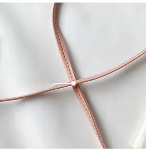 Detail shot of the pink leather shoulder strap with precise stitching on a mini bag