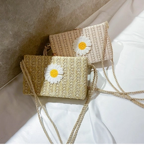 Détail de sacs bandoulière en paille style enveloppe avec broderie marguerite délicate