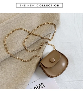 Close-up of khaki mini saddle bag with fine leather texture and gold chain strap