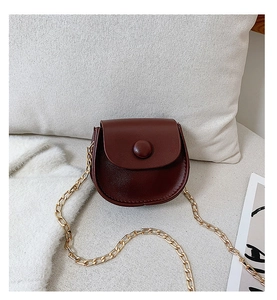 Detailed close-up of dark red leather mini crossbody bag with gold chain strap