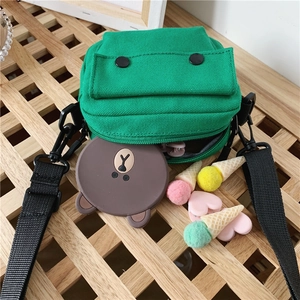Minimalist green canvas crossbody bag for kids with black strap and front pocket