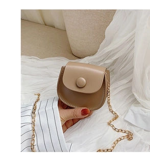 Detail of khaki PU leather mini saddle bag with golden chain strap and round button