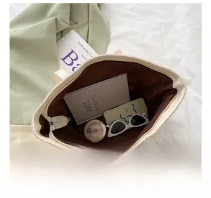 Top view of spacious beige woven tote bag interior showing books and daily essentials