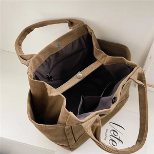 Brown canvas tote bag with multi-compartment interior and magnetic snap closure