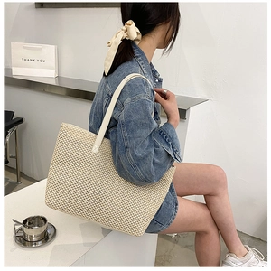 Close-up of a large woven linen tote bag showing natural cream texture and flat shoulder strap