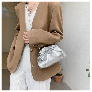 Sac nuage argenté plissé porté avec un blazer camel pour un look urbain et élégant