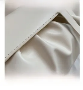 Detailed close-up of cream pleated shoulder bag showing zipper edges and precise stitching