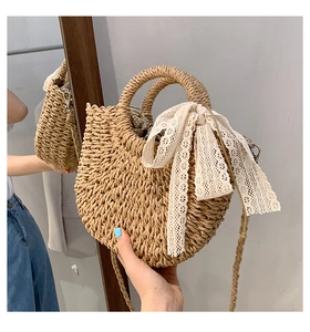 Detail of hand-held beige woven beach bag with white lace bow and polka dot lining