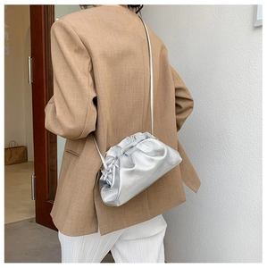 Détail du sac nuage argenté plissé avec texture cuir et fine bandoulière sur mannequin