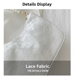 Close-up of white floral lace texture and pearl strap on the elegant baguette bag