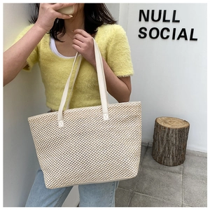 Close-up of the woven texture and reinforced handle on this cream linen tote bag