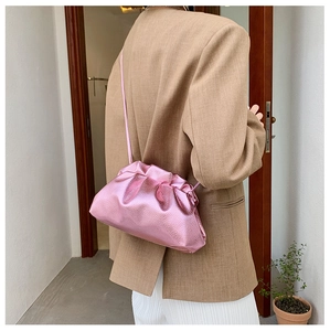 Sac nuage plissé rose métallisé tendance porté à l'épaule avec une tenue élégante